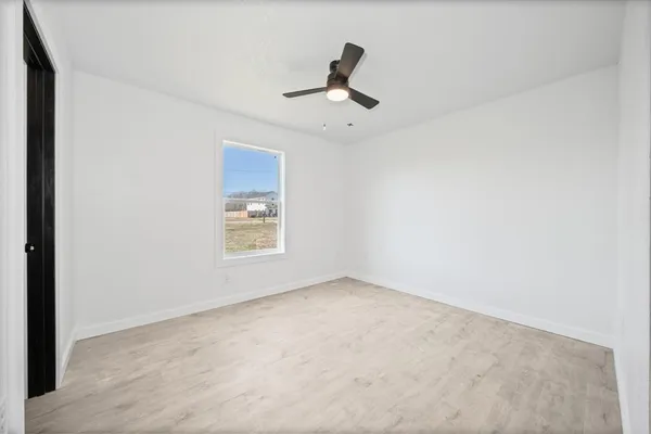 a view of an empty room with a ceiling fan