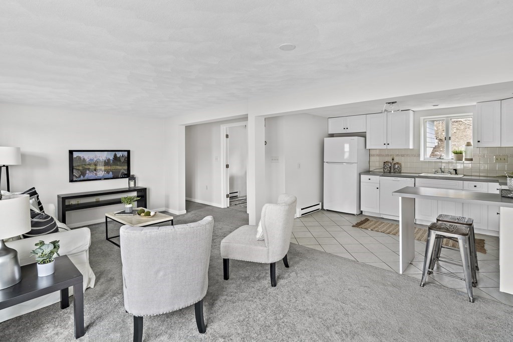 45 Brookbridge Road Stoneham, MA 02180 - Photo 17 of 34 a living room with furniture a flat screen tv and a table