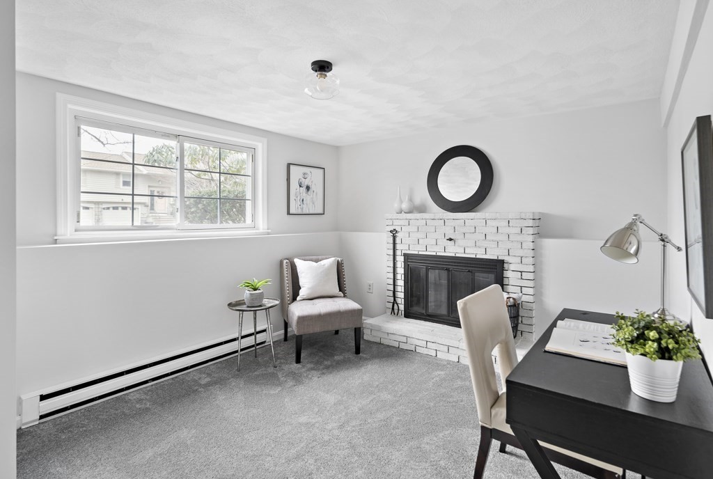 45 Brookbridge Road Stoneham, MA 02180 - Photo 23 of 34 a living room with furniture a fireplace and a potted plant