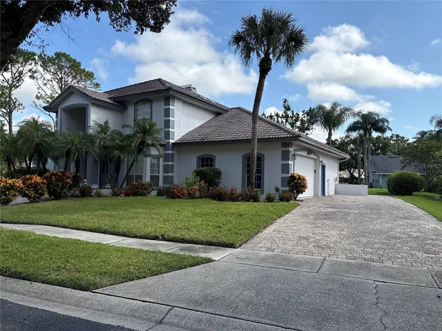 a front view of a house with a garden and trees