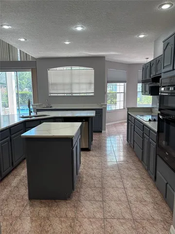 a kitchen with stainless steel appliances granite countertop a stove a sink and a microwave