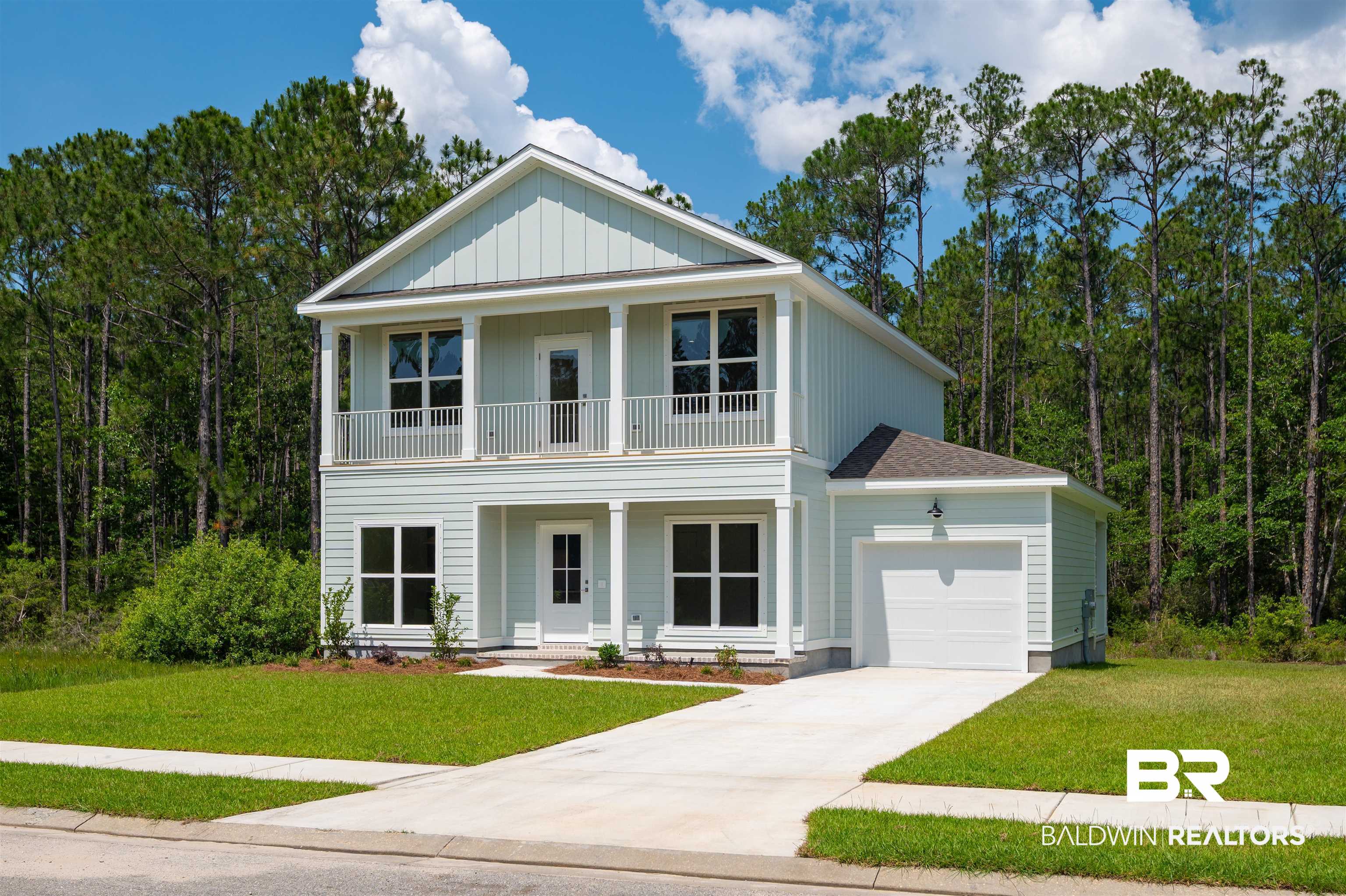 657 Island Way Gulf Shores, AL 36542 - Photo 37 of 59 View of front of property featuring a balcony, a garage, a porch, driveway, and a front yard