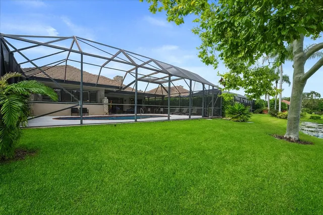a view of a lake with a big yard and palm trees