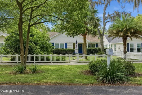 a view of house with a big yard and potted plants