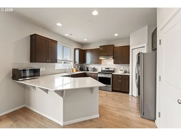 a kitchen with stainless steel appliances granite countertop a refrigerator sink and stove