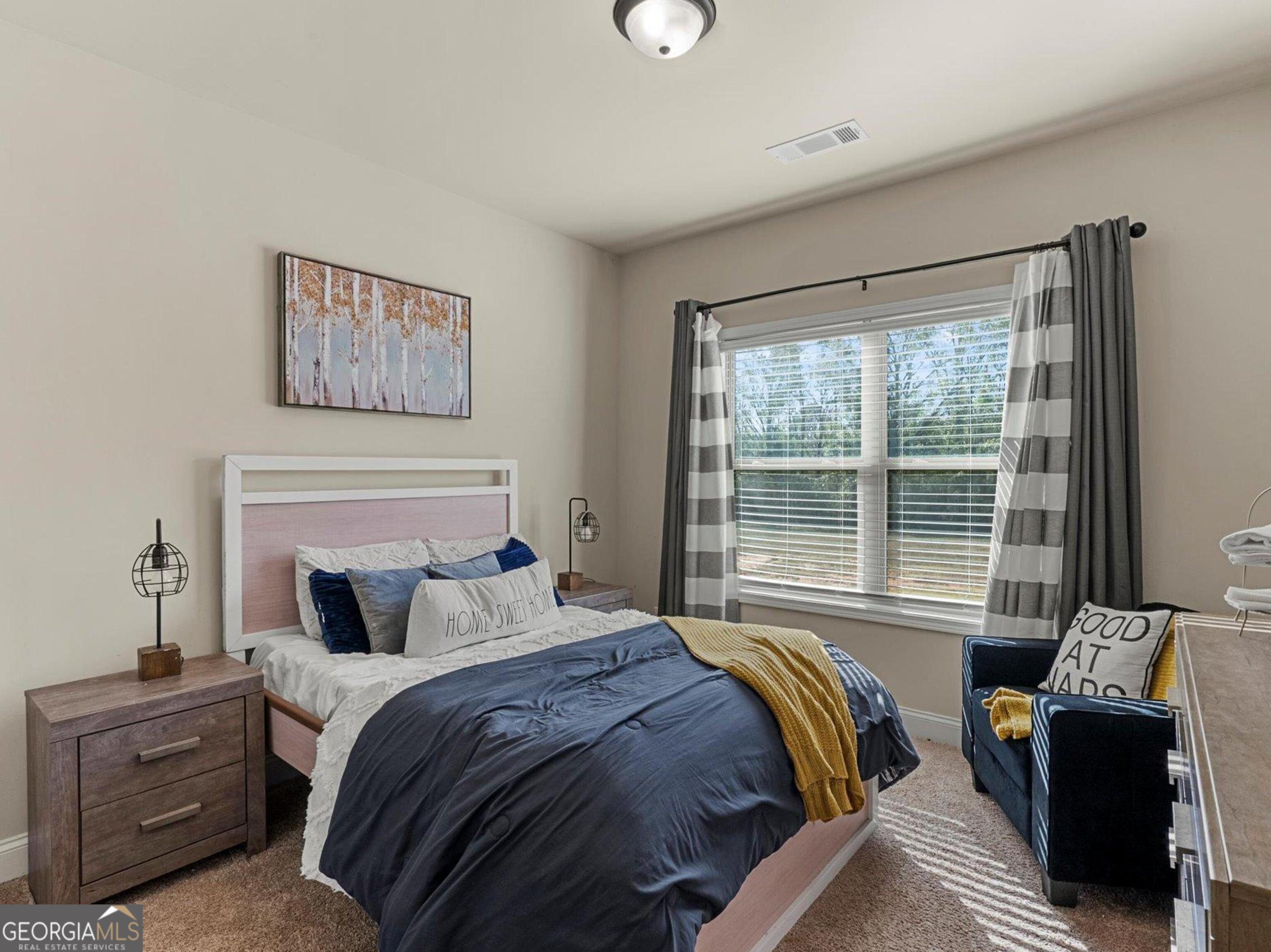 976 Jackson Street Locust Grove, GA 30248 - Photo 11 of 17 a bedroom with a bed and glass window