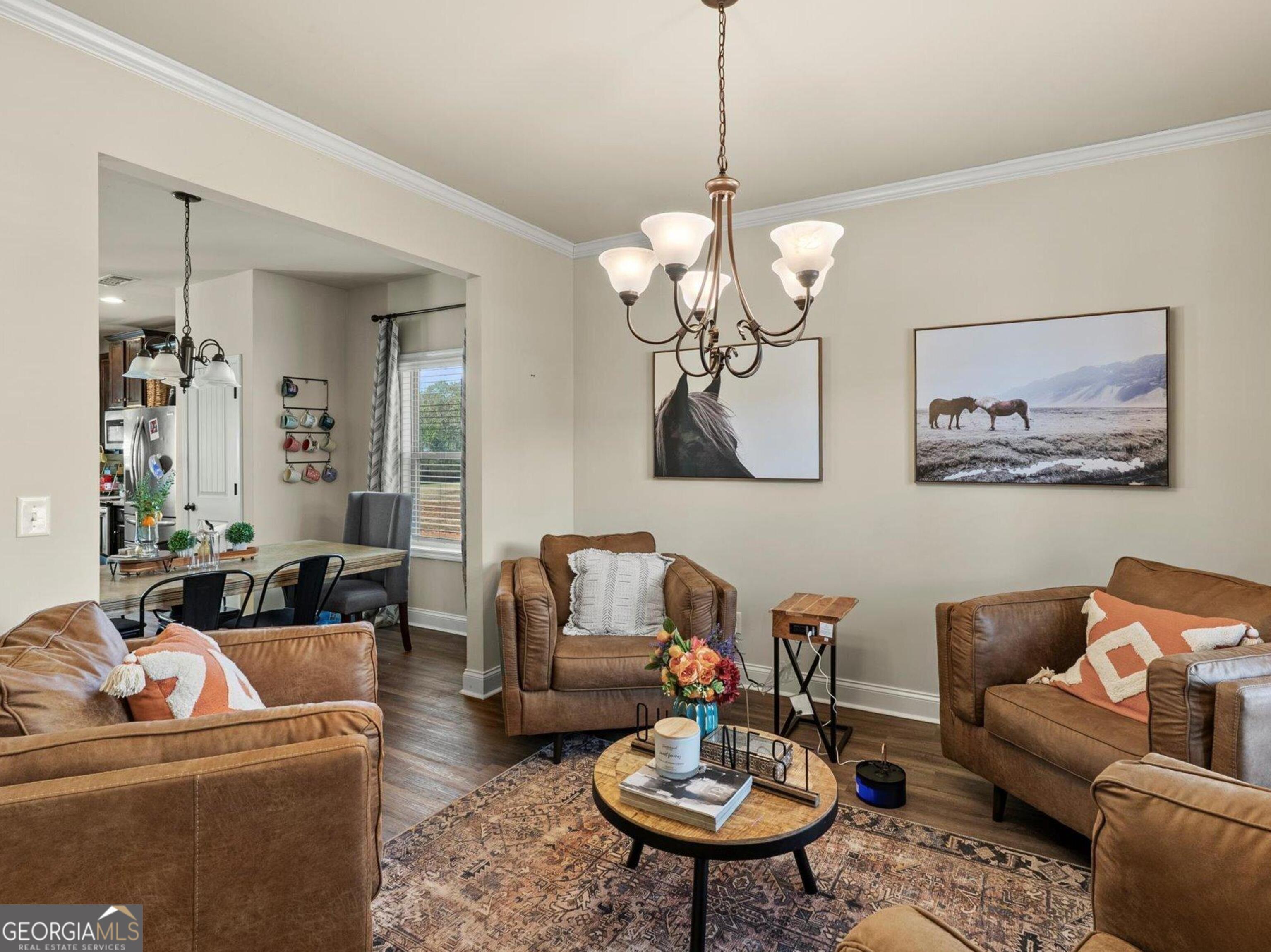 976 Jackson Street Locust Grove, GA 30248 - Photo 4 of 17 a living room with furniture a chandelier and a table