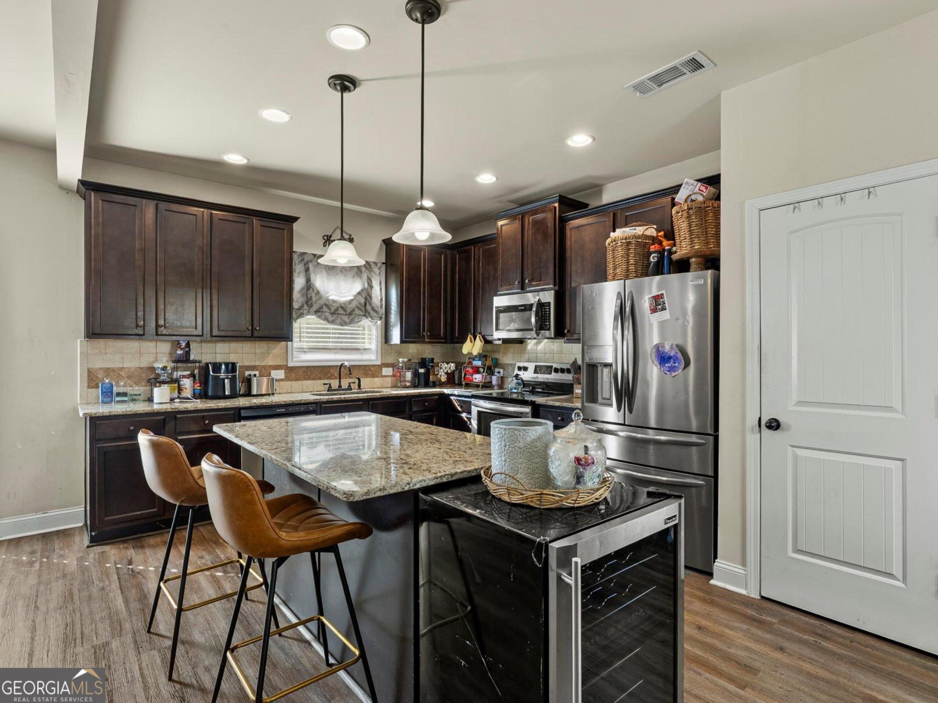 976 Jackson Street Locust Grove, GA 30248 - Photo 6 of 17 a kitchen with a table chairs stove and refrigerator