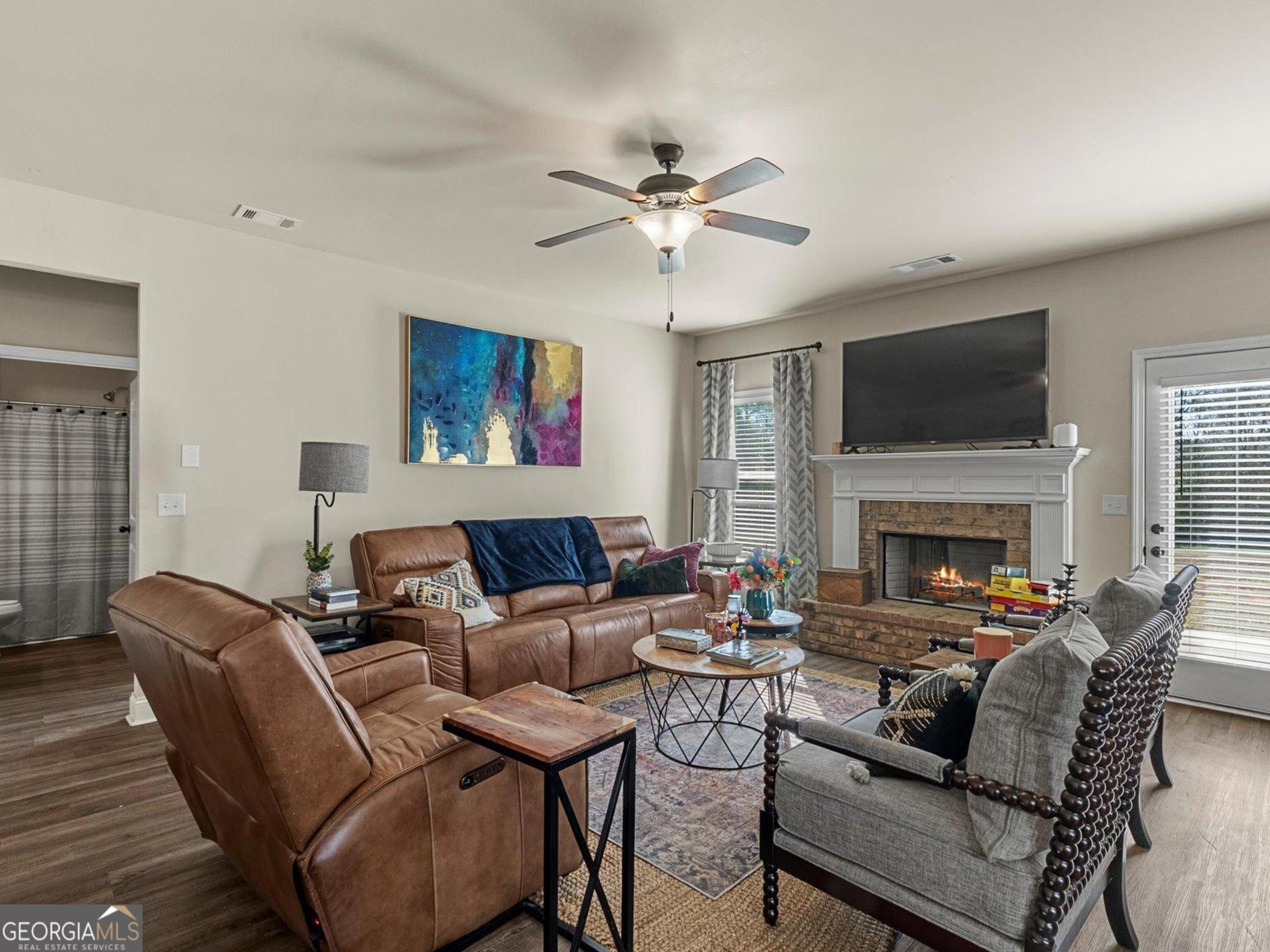 976 Jackson Street Locust Grove, GA 30248 - Photo 8 of 17 a living room with furniture a fireplace and a flat screen tv