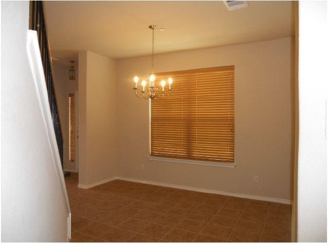 1310 West Parmer Lane, Unit 1503 Austin, TX 78727 - Photo 11 of 26 Unfurnished room with hanging lights and baseboards