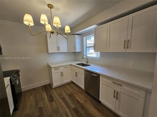 a kitchen with a sink cabinets and wooden floor