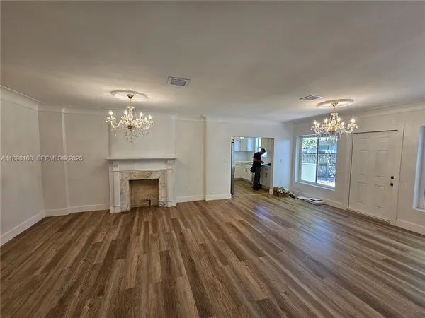 a view of a livingroom with wooden floor and chandelier