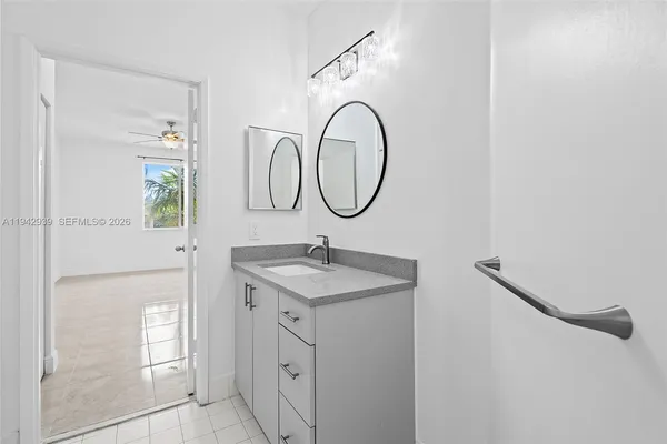a bathroom with a granite countertop sink a mirror and a shower