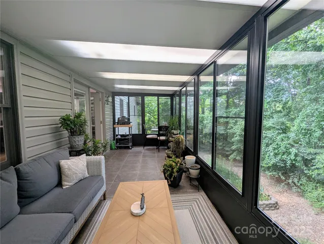 a living room with furniture and a floor to ceiling window