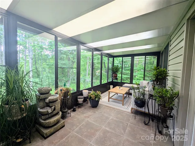 a living room with furniture and floor to ceiling windows