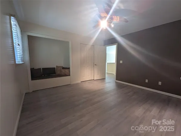 a view of a livingroom with a ceiling fan and wooden floor