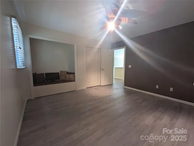 a view of a livingroom with a ceiling fan and wooden floor