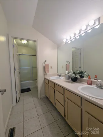 a bathroom with a double vanity sink a toilet and a mirror