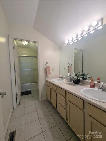 a bathroom with a double vanity sink a toilet and a mirror