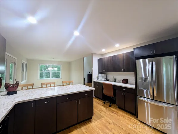 a kitchen with stainless steel appliances granite countertop a sink refrigerator and cabinets