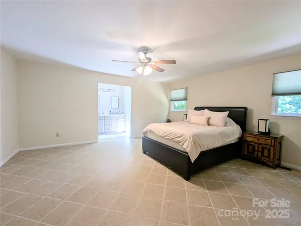 a bedroom with a large bed and a chandelier