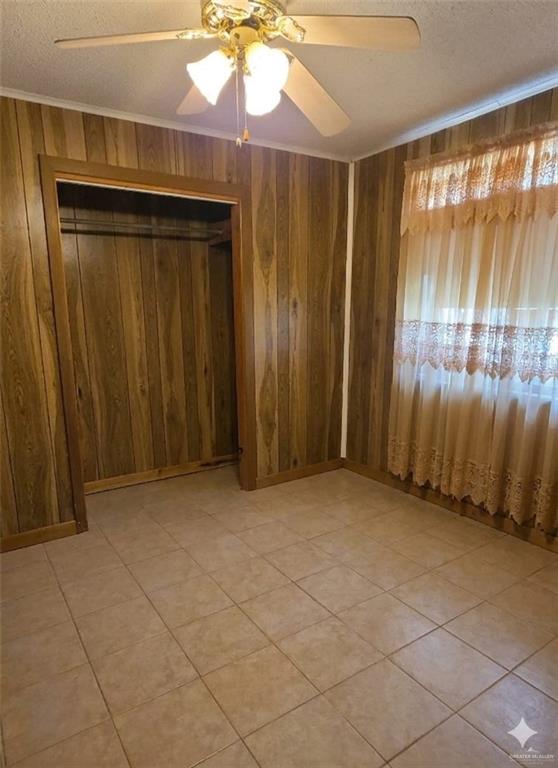 4347 Highway 83 Rio Grande City, TX 78582 - Photo 10 of 15 This room features wood paneling, tiled flooring, and a ceiling fan with integrated lighting