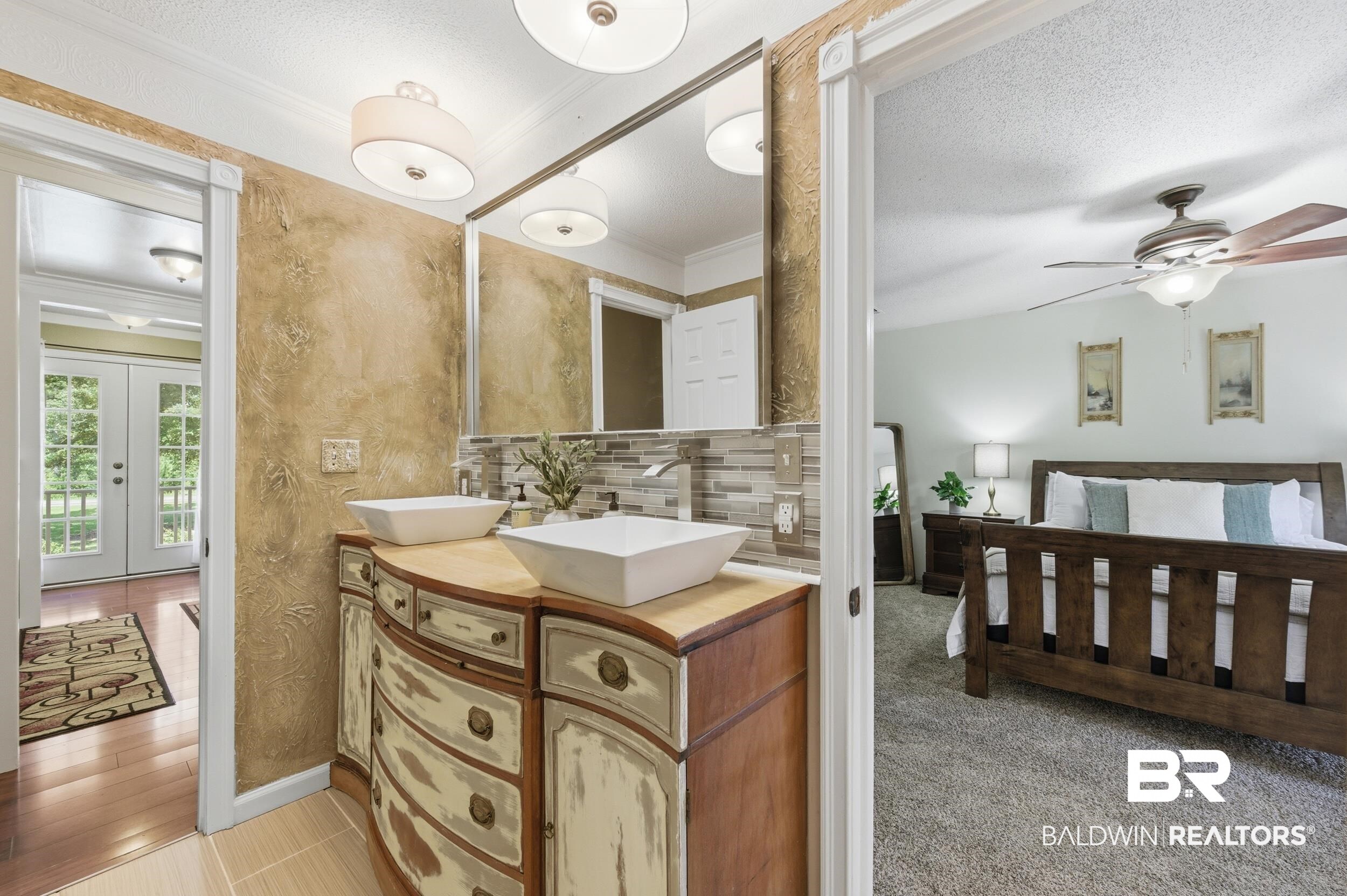 51620 Robert White Road Bay Minette, AL 36507 - Photo 46 of 81 Double vanity featuring two vessel sinks, wall-mounted faucets, and a light-toned countertop