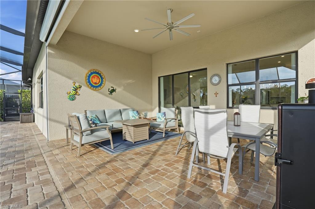 17210 Ashcomb Way Estero, FL 33928 - Photo 38 of 47 a living room with a table and a dining table with a large window