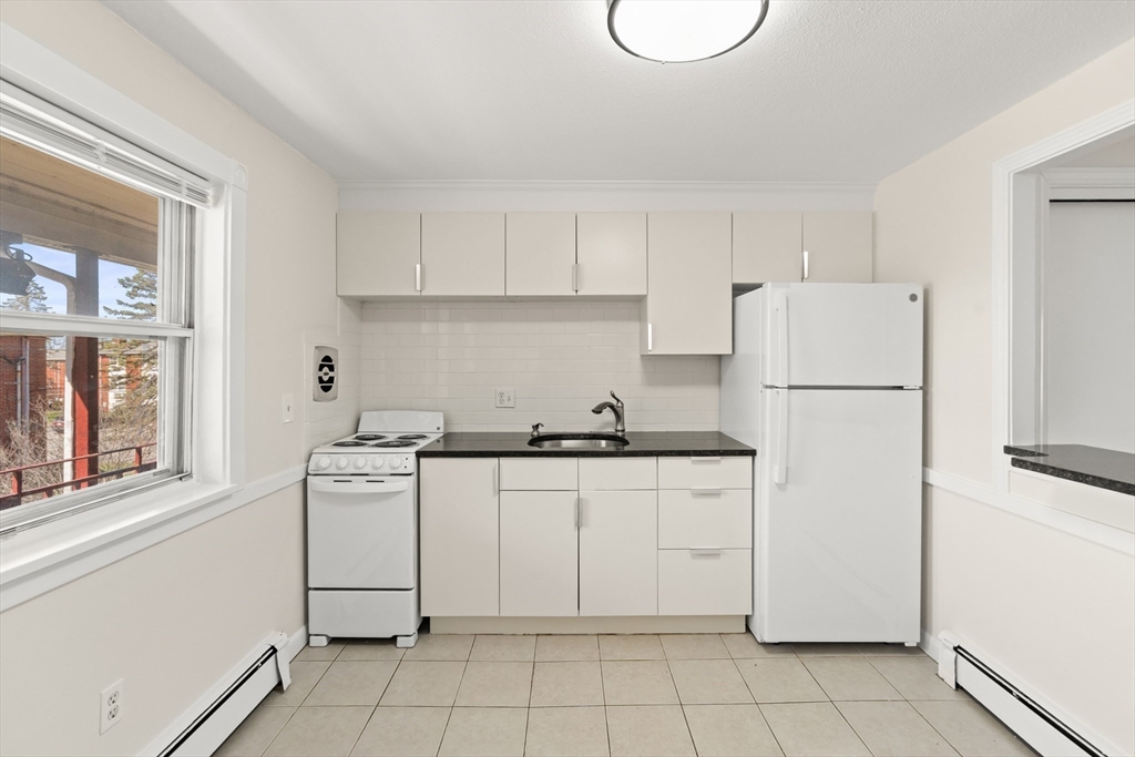 2 Colonial Drive, Unit E25 Andover, MA 01810 - Photo 11 of 17 a kitchen with white cabinets and white appliances