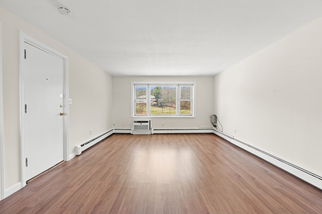 2 Colonial Drive, Unit E25 Andover, MA 01810 - Photo 5 of 17 an empty room with wooden floor and windows