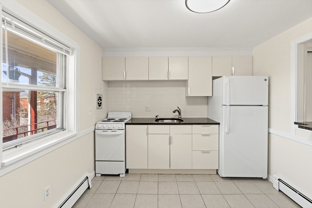2 Colonial Drive, Unit E25 Andover, MA 01810 - Photo 8 of 17 a kitchen with white cabinets and white appliances