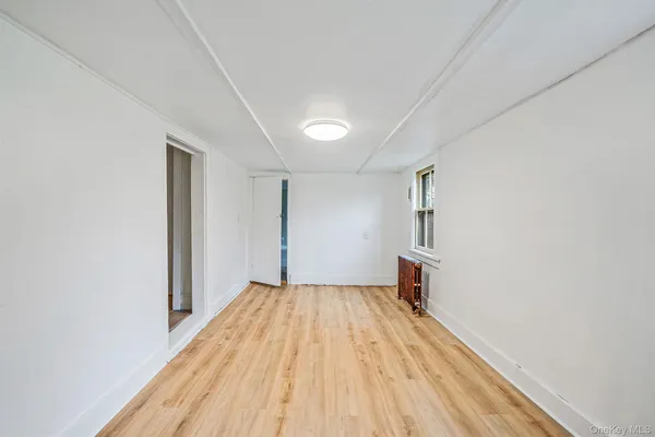 a view of a room with wooden floor and a window