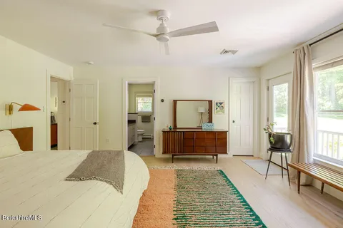 a bedroom with a large bed a chandelier and windows