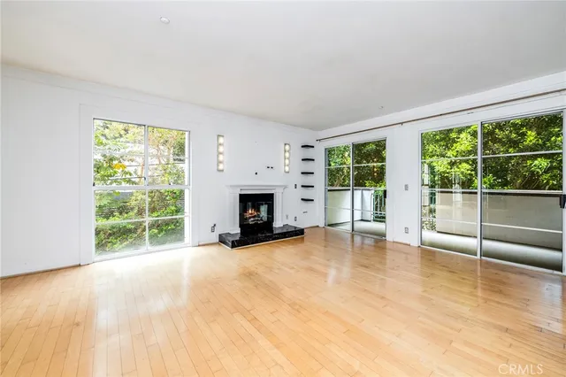 an empty room with windows and fireplace