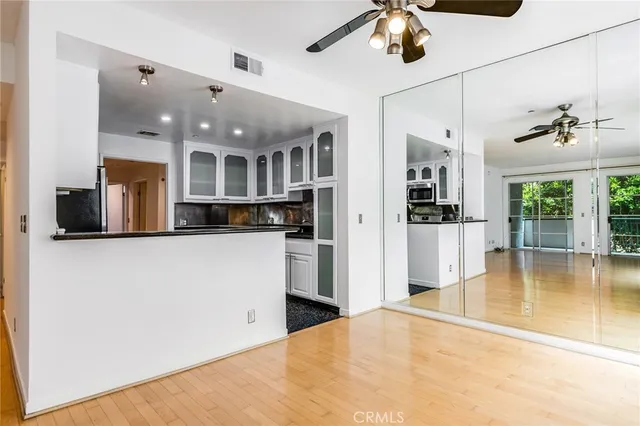 a view of a kitchen with a refrigerator a fireplace and a living room