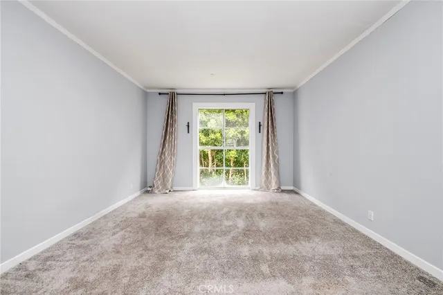 a view of an empty room with a fireplace and a window
