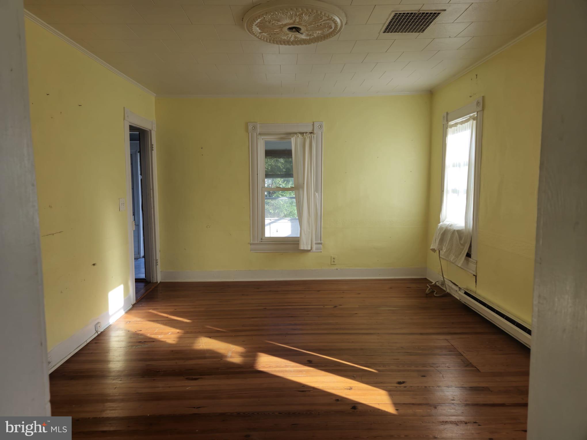 8034 Bozman Neavitt Road St. Michaels, MD 21663 - Photo 17 of 22 an empty room with wooden floor and windows