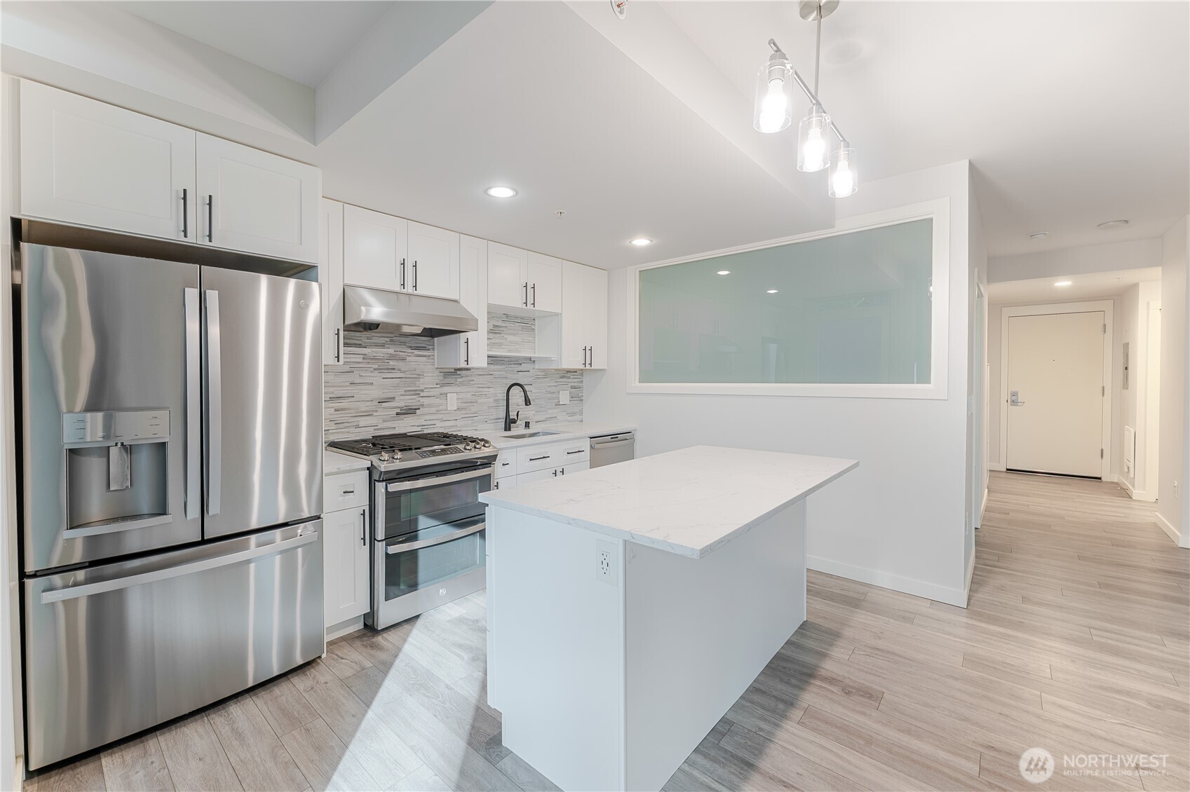 76 Cedar Street, Unit 303 Seattle, WA 98121 - Photo 10 of 29 a kitchen with stainless steel appliances a refrigerator sink and stove
