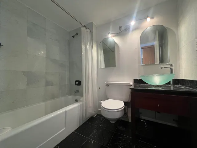 a bathroom with a sink toilet a mirror and bathtub