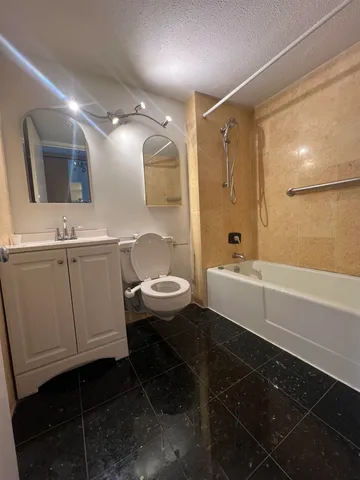 a bathroom with a sink a toilet a mirror and shower