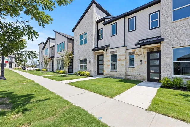front view of a brick house with a yard