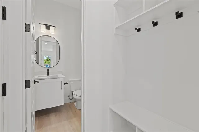 a bathroom with a toilet mirror and vanity