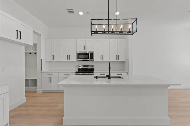 a kitchen with stainless steel appliances a refrigerator sink and stove