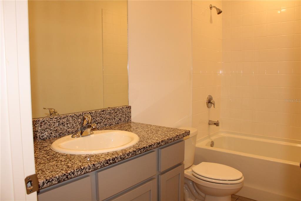 17567 Crescent Moon Loop Bradenton, FL 34211 - Photo 29 of 51 a bathroom with a granite countertop sink toilet and shower