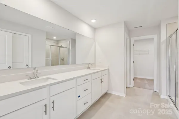 a bathroom with double sink and a mirror
