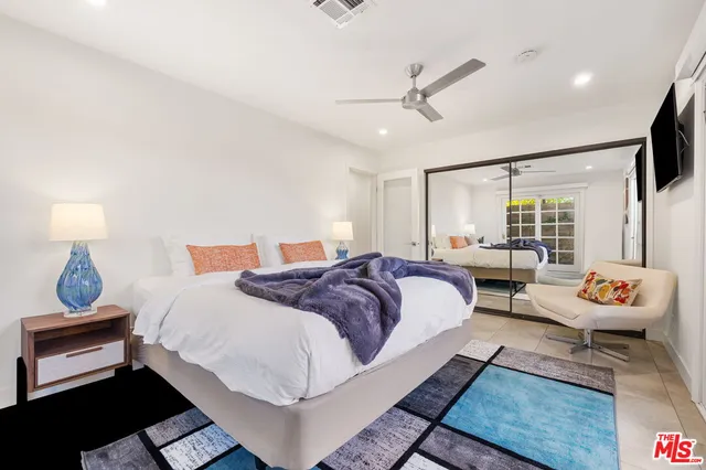 a bedroom with a bed and a painting on the wall