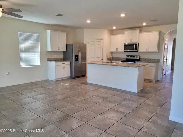 a kitchen with stainless steel appliances a refrigerator sink and microwave
