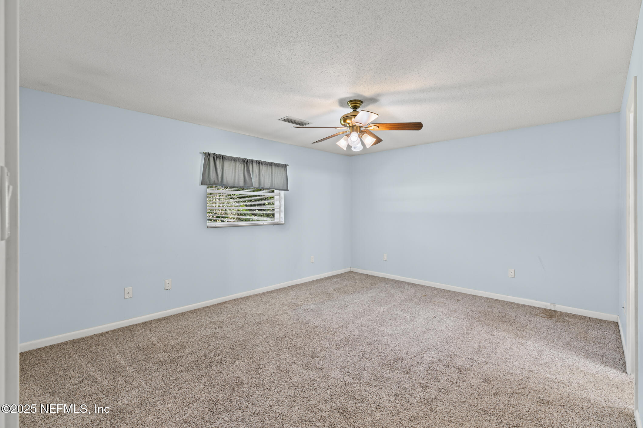 1388 Highland Boulevard St. Augustine, FL 32084 - Photo 13 of 54 an empty room with a chandelier fan and windows