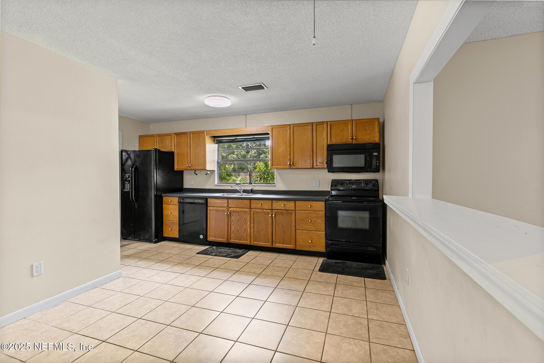 1388 Highland Boulevard St. Augustine, FL 32084 - Photo 29 of 54 a kitchen with a refrigerator a stove top oven and a sink