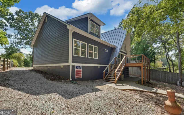 an aerial view of residential house with outdoor space and trees all around
